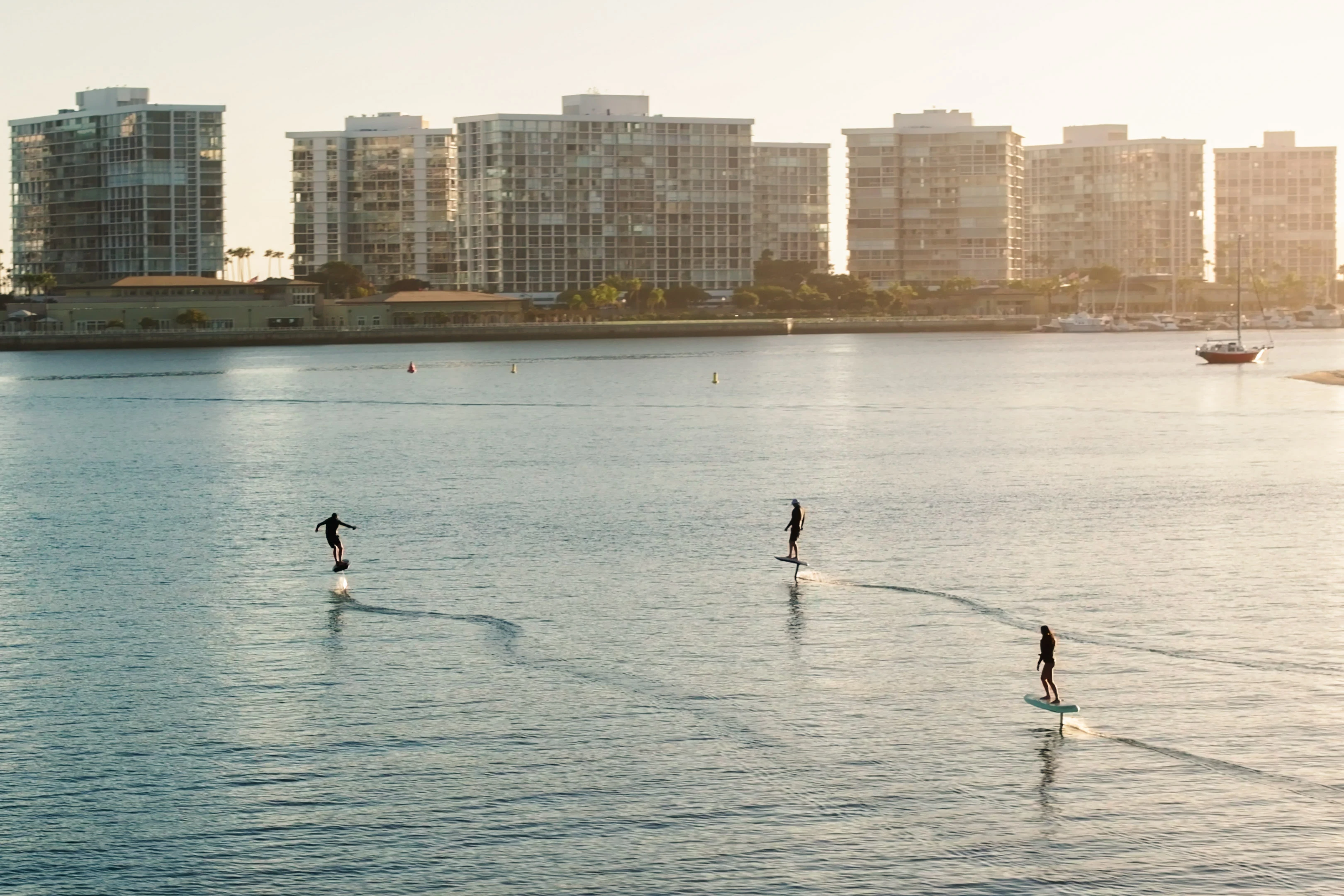 Three Fliteboard eFoils flying in formation at golden hour on San Diego Bay