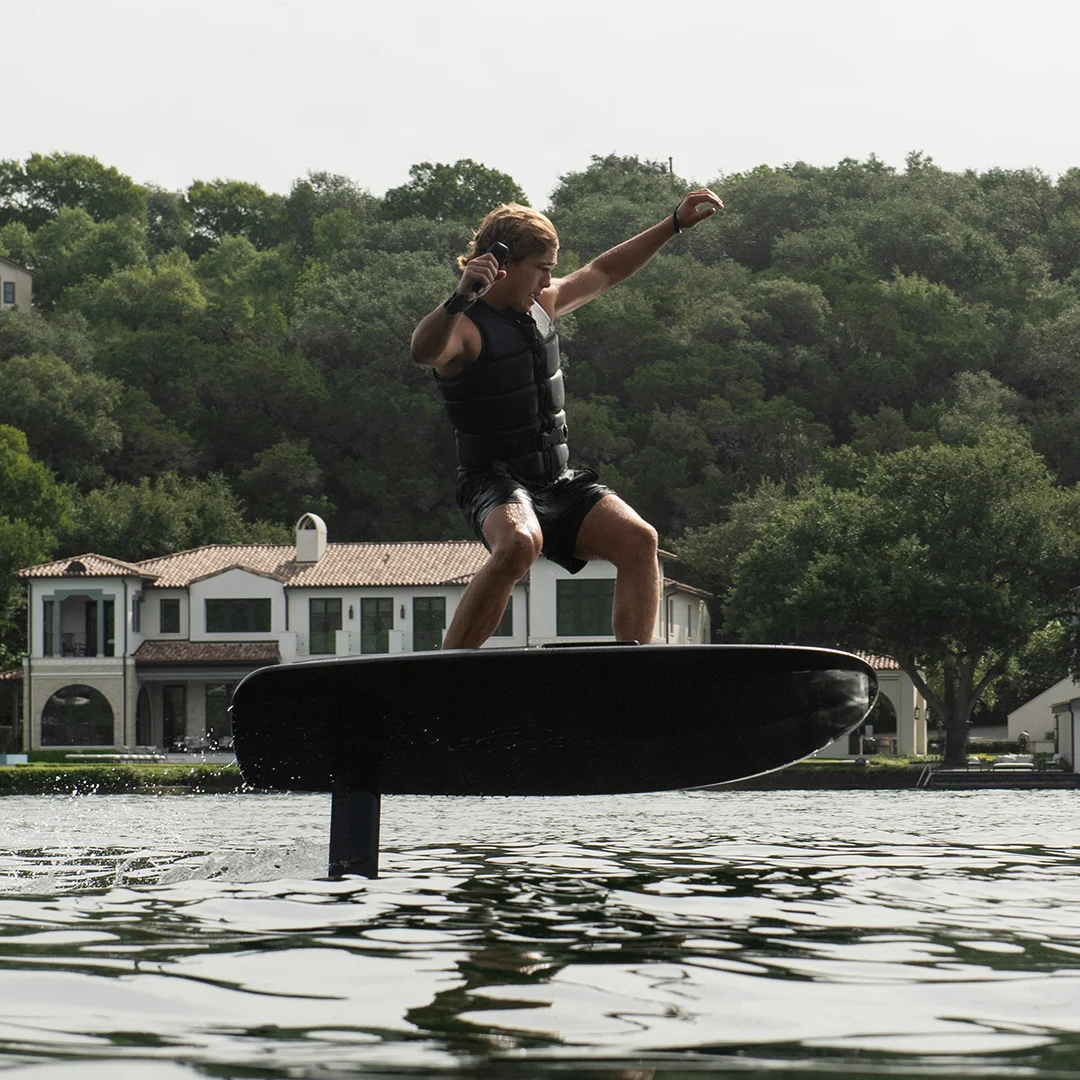 Fliteboard rider mid-flight during charter-style lake use — 2026 commercial warranty context
