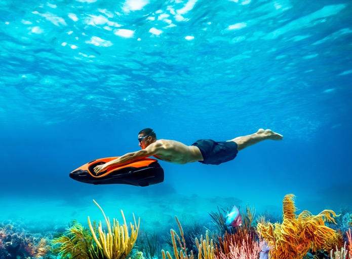 Diver gliding with a Seabob over a Mediterranean coral reef &mdash; the kind of mid-charter use that exposes any seal or anode issue